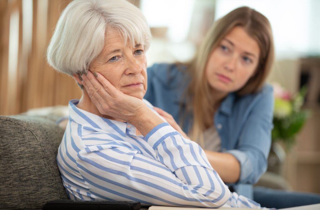A senior sits frustrated with their adult child after having a disagreement about a memory.