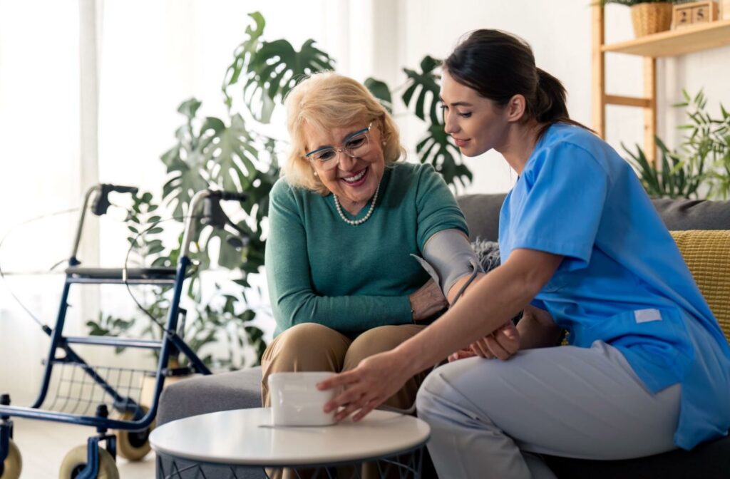 A caregiver measures the blood pressure of a senior personal care resident.