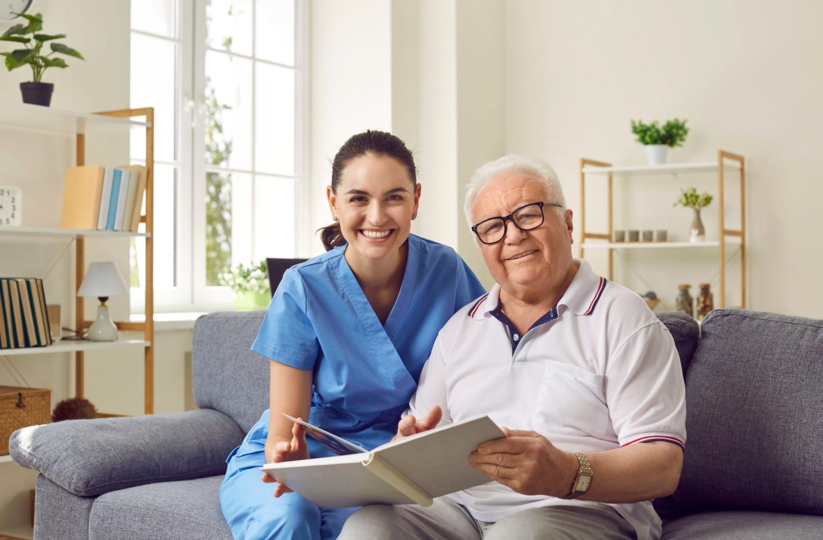 a carer and a senior smile at the camea